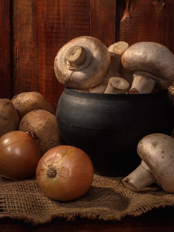 mushrooms in a cast iron pot on a dark wooden background in a rustic style